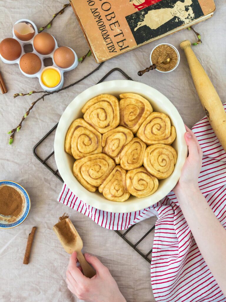 pexels-photo-302544-302544 Top view of homemade cinnamon rolls with ingredients on a table, showcasing the baking process.